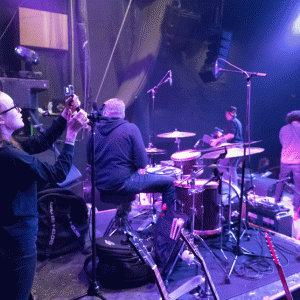 A student from RAM Productions films a band at the Aggie Theatre