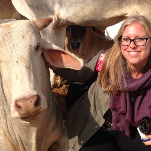 Kelsi Nagy smiles with cows in India during research trip
