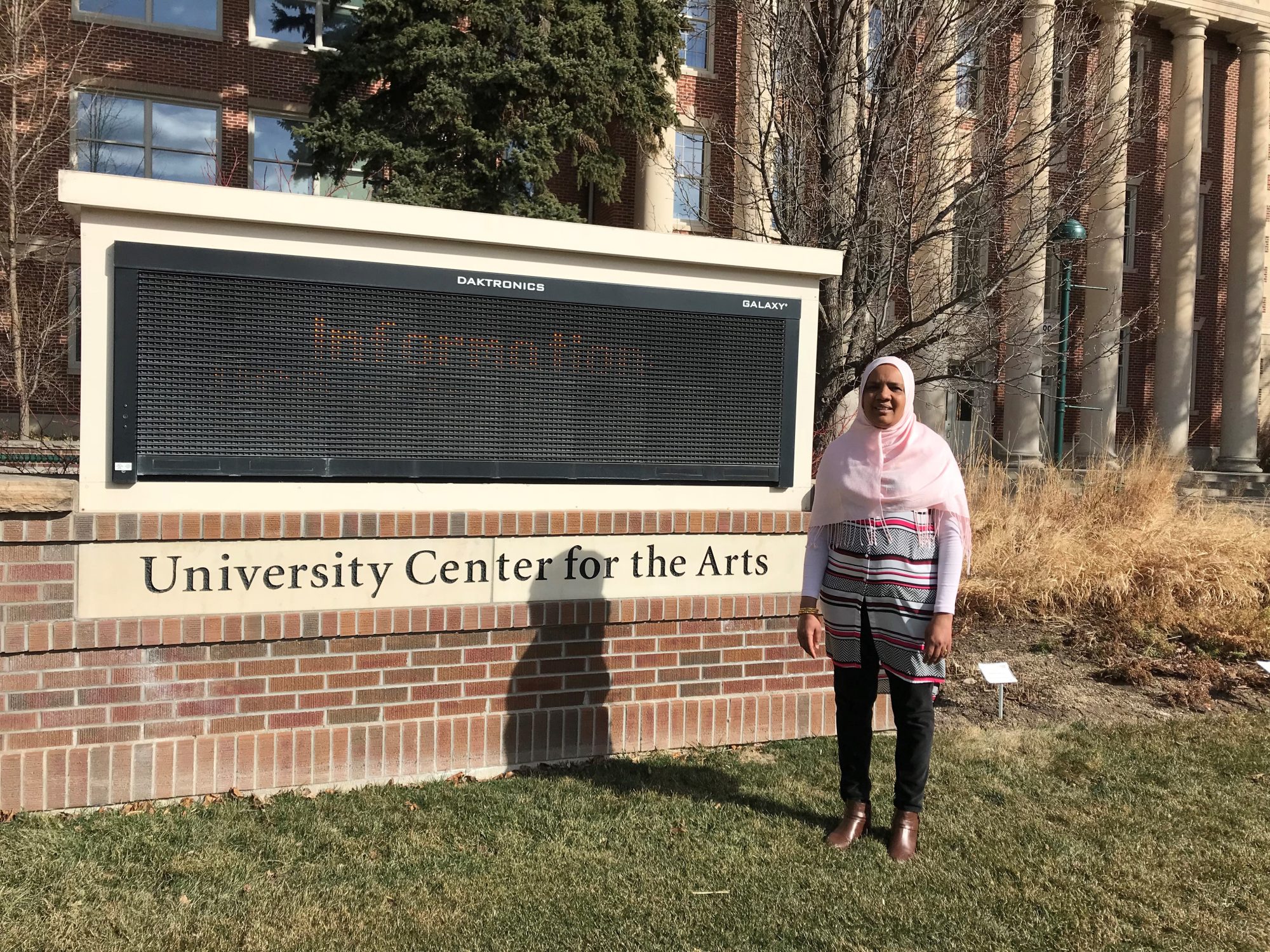 Elham Musa in front of the University Center for the Arts