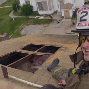 Tim Amidon on the roof of a house as part of the Westerly Fire Department