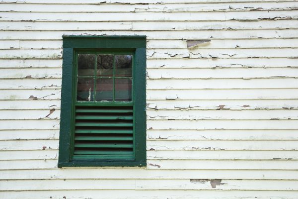 Architectural Details show peeling paint and an old window