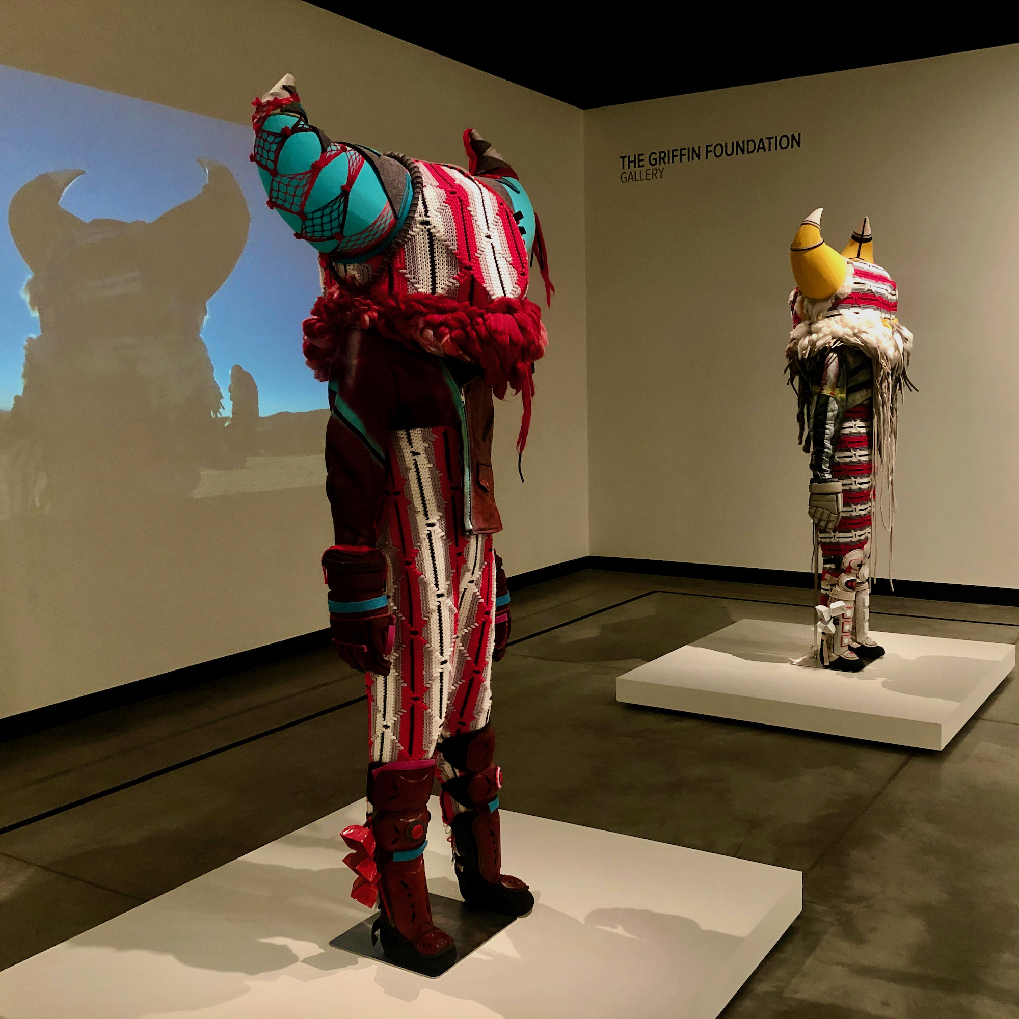Cannupa Hanska Luger’s “Muscle, Bone &amp; Sinew” (2021, regalia on mannequins) and “Shadow holding shape to experience the energy of the sun” (working title) (2021, digital video), image courtesy of Madeleine Boyson, work on loan from the artist 