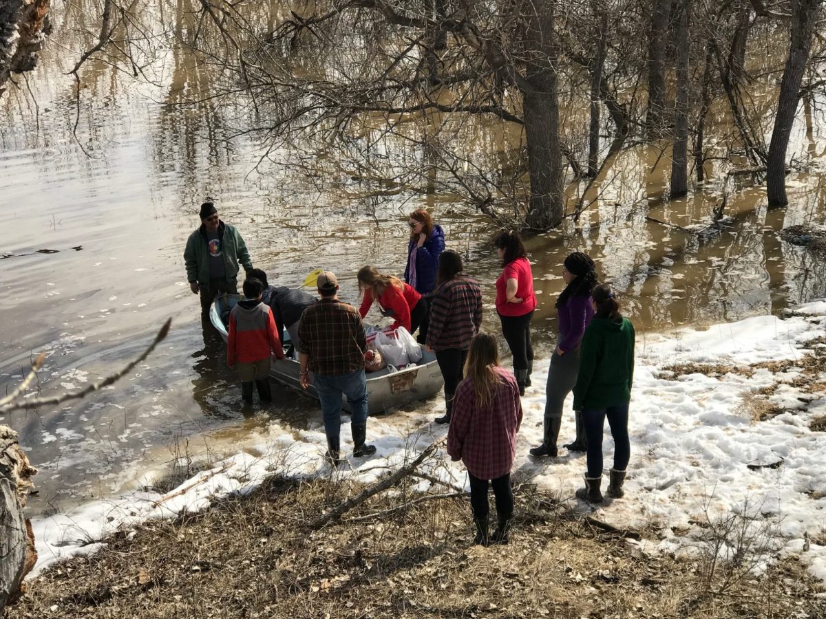 CSU students help Henry Red Cloud and his family move their belongings from his house to dry land after it became fully surrounded by water. 