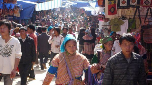 Sapa market town crowded with Vietnamese people in colorful clothing and hats
