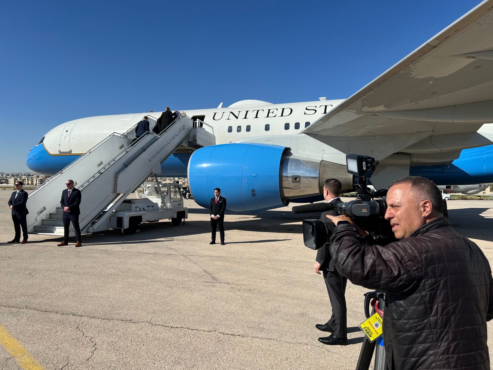 Stratis Zervos holding a camera to record Antony Blinken departing from Andrew Air Force Base on a diplomatic mission