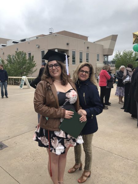 Emily Myler posing with a family member at Moby Arena after her commencement ceremony