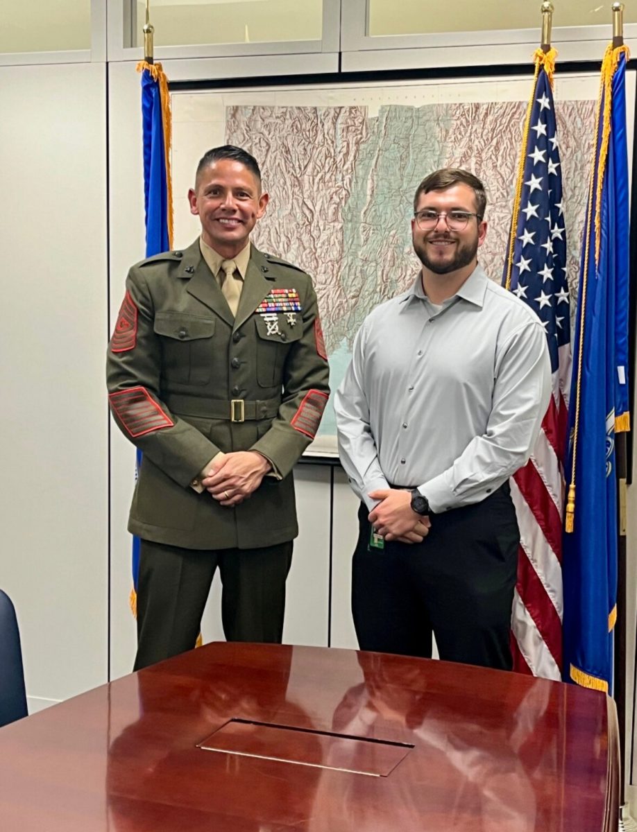 Justin Frigault in a Capital conference room with a military service member in uniform