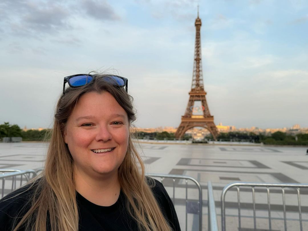 Megan Rakoczy smiling in front of the Eiffel Tower during the 2024 Olympic Games in Paris, France