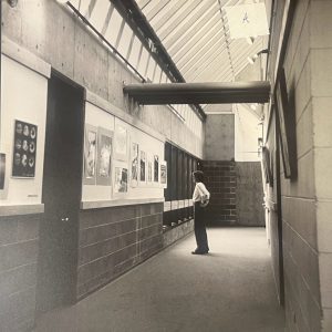 Person looks at student art in the hallway of the Visual Arts Building shortly after it was constructed in 1977