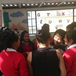 Students gather in a circle inside a classroom in Colombia