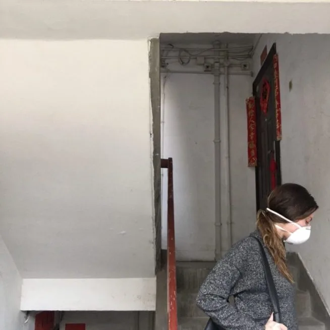 Kristen Mullen walks up a stairwell in a surgical mask to defend against the novel coronavirus and its disease, COVID-19.